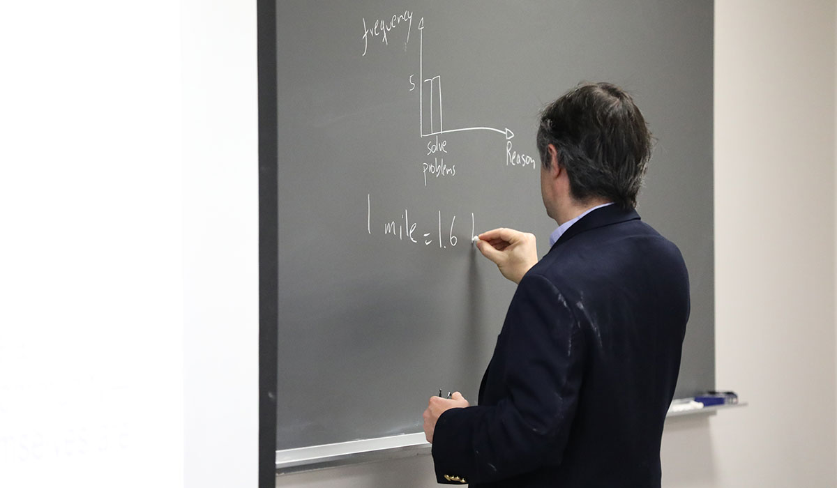Professor writing on a blackboard
