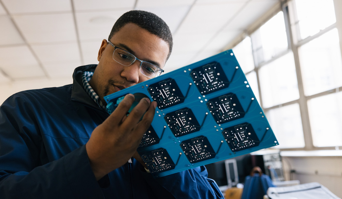Student holding computer hardware
